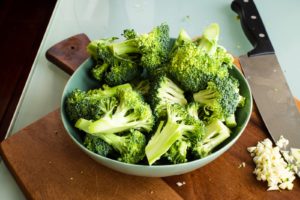 Cruciferous green broccoli on brown wooden chopping board